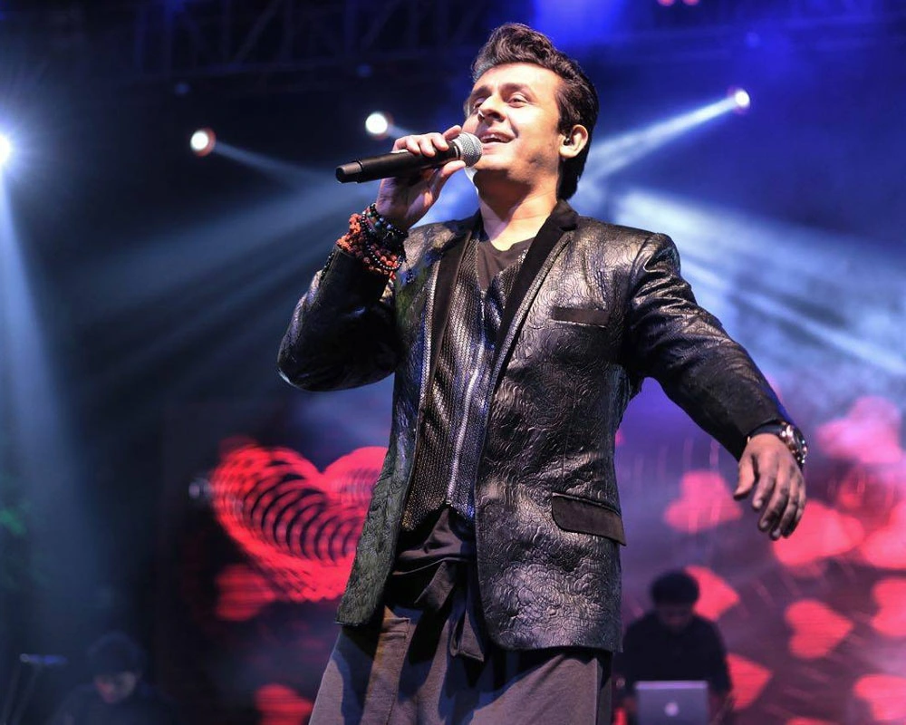 Performers on a blue-lit stage at The Sonu Nigam Show